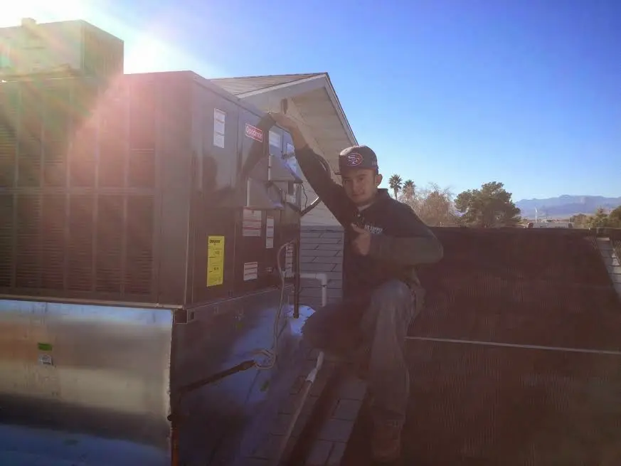 HVAC technician performing AC Tune-Up on a rooftop unit in West Haverstraw